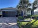 Charming home with mature landscaping, paver driveway, dark gray trim and a two-car garage at 10267 Julia Isles Ave, Oxford, FL 34484