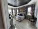 Spacious main bedroom with tray ceiling, large windows, stylish wallpaper, and elegant furnishings at 10267 Julia Isles Ave, Oxford, FL 34484