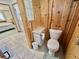 This bathroom features wood paneling, tiled floors and a standard toilet at 104 Chestnut St, Leesburg, FL 34748