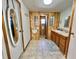 Bathroom featuring wood paneled walls, a neutral-toned tiled floor, and a single vanity sink at 104 Chestnut St, Leesburg, FL 34748