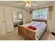 Carpeted bedroom with a ceiling fan, a bed, and mirrored closet doors at 104 Chestnut St, Leesburg, FL 34748