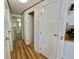 Bright hallway with wood-look floors, leading to bedrooms, and closet storage space at 104 Chestnut St, Leesburg, FL 34748