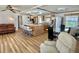 Open living area with a kitchen, island, dining table, and comfortable sofas at 104 Chestnut St, Leesburg, FL 34748