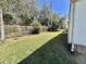Side yard featuring green grass, mature trees, and chain link fence at 104 Chestnut St, Leesburg, FL 34748