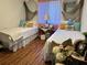 Comfortable bedroom featuring hardwood floors, twin beds, and stylish nautical decor at 12237 Tavares Ridge Cir # 67, Tavares, FL 32778