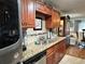 Close up of the kitchen with beautiful granite counters and cabinetry, stainless steel appliances, and tile backsplash at 12237 Tavares Ridge Cir # 67, Tavares, FL 32778