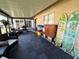 Enclosed sun room with tile flooring, seating and decorated surfboards at 12237 Tavares Ridge Cir # 67, Tavares, FL 32778