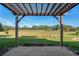 A paver patio features a wooden pergola overlooking the expansive backyard at 12239 Se 92Nd Court Rd, Summerfield, FL 34491