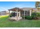 The backyard features a paver patio, wooden pergola, and green lawn at 12239 Se 92Nd Court Rd, Summerfield, FL 34491