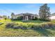 Backyard view of house with lush green lawn, patio and wooden pergola at 12239 Se 92Nd Court Rd, Summerfield, FL 34491