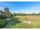View of the backyard featuring green lawn, wooden pergola and extensive property at 12239 Se 92Nd Court Rd, Summerfield, FL 34491
