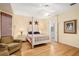 Charming bedroom featuring a four-poster bed, wood floors, ceiling fan and inviting natural light at 12239 Se 92Nd Court Rd, Summerfield, FL 34491