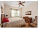 Cozy bedroom with a comfortable bed, wooden floors, window, dresser, and decorative mirror at 12239 Se 92Nd Court Rd, Summerfield, FL 34491