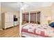 Well-lit bedroom featuring a four-poster bed, sitting area, and hardwood floors at 12239 Se 92Nd Court Rd, Summerfield, FL 34491