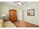 Comfortable bedroom showcases a daybed, hardwood floors, a ceiling fan, and a large wooden wardrobe at 12239 Se 92Nd Court Rd, Summerfield, FL 34491