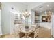 Bright dining area features a mosaic table, a chandelier, and built-in shelving for storage and display at 12239 Se 92Nd Court Rd, Summerfield, FL 34491