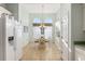 Bright dining area with chandelier and arched windows with adjacent white kitchen at 12239 Se 92Nd Court Rd, Summerfield, FL 34491