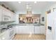 Bright kitchen with white cabinets, appliances, and a pass-through to another room for easy serving at 12239 Se 92Nd Court Rd, Summerfield, FL 34491