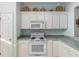 Bright kitchen features white cabinets and appliances, offering a clean and functional cooking space at 12239 Se 92Nd Court Rd, Summerfield, FL 34491