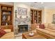 Cozy living room with brick fireplace, built-in shelving, and comfortable seating at 12239 Se 92Nd Court Rd, Summerfield, FL 34491