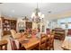 Open-concept living area with hardwood dining table, chandelier, and vintage organ at 12239 Se 92Nd Court Rd, Summerfield, FL 34491