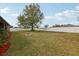 Wide backyard space enclosed by a white fence and a large tree at 13101 Biscayne Dr, Grand Island, FL 32735