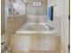 Bathroom showcasing a tiled tub with a glass shower and decorative tile accents at 13101 Biscayne Dr, Grand Island, FL 32735