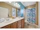 Bathroom featuring a double sink vanity, tub/shower combo, and blue accent wall at 13101 Biscayne Dr, Grand Island, FL 32735