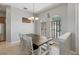 Bright dining room featuring a rustic wooden table, white chairs, arched windows, and stylish lighting at 13101 Biscayne Dr, Grand Island, FL 32735