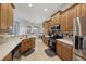Kitchen area with wooden cabinets, tile floors, stainless steel appliances, and tile backsplash at 13101 Biscayne Dr, Grand Island, FL 32735