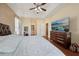 Large main bedroom with a tray ceiling, television, hardwood flooring, and large bed at 13101 Biscayne Dr, Grand Island, FL 32735