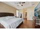 Spacious main bedroom featuring hardwood floors, ceiling fan, and ensuite bathroom entrance at 13101 Biscayne Dr, Grand Island, FL 32735