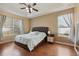 Main bedroom features hardwood floors, ceiling fan, and natural light from the large windows at 13101 Biscayne Dr, Grand Island, FL 32735
