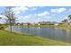 Picturesque backyard view of a tranquil lake lined with lush greenery and neighboring homes at 1581 Rowell St, The Villages, FL 34762