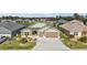 Home exterior features a two-car garage, well-maintained lawn, and complemented by beautifully landscaped front yard at 1581 Rowell St, The Villages, FL 34762