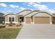 Charming home with a well-manicured lawn and a two-car garage, showcasing inviting curb appeal at 1581 Rowell St, The Villages, FL 34762