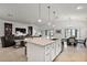Open concept, showcasing the kitchen island, granite countertops, stainless steel appliances and sightlines to the living area at 1581 Rowell St, The Villages, FL 34762