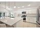 Modern kitchen with stainless steel appliances, bright white cabinets, and a central island with granite countertops at 1581 Rowell St, The Villages, FL 34762