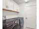 Laundry room with modern gray washer and dryer, white cabinets, and a clean, organized space at 1581 Rowell St, The Villages, FL 34762