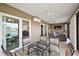 Bright sunroom featuring glass table and modern furniture, offering indoor-outdoor living with views of the backyard at 1581 Rowell St, The Villages, FL 34762
