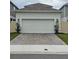 Two car garage with a paved driveway and manicured lawn at 1723 Happiness Row, Kissimmee, FL 34744