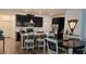 Kitchen with a dark wood table, light colored chairs, dark cabinets, stainless steel appliances, and hardwood floors at 1723 Happiness Row, Kissimmee, FL 34744