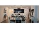 A dining table with chairs sits in front of a modern kitchen with stainless steel appliances and dark cabinets at 1723 Happiness Row, Kissimmee, FL 34744