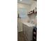 Laundry room with a full size washer and dryer, wood-look tile floors, and overhead shelving at 1723 Happiness Row, Kissimmee, FL 34744