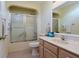 Cozy bathroom featuring a shower with glass doors and light wood cabinets at 17490 Se 110Th Ter, Summerfield, FL 34491