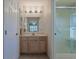 Bright bathroom features a vanity with a sink, a mirror, and a glass-enclosed shower, providing a clean and functional space at 17490 Se 110Th Ter, Summerfield, FL 34491