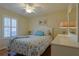 Cozy bedroom featuring a large window, ceiling fan, and patterned bedding at 17490 Se 110Th Ter, Summerfield, FL 34491