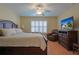 Relaxing main bedroom with a ceiling fan, shuttered windows, and wood-look floors at 17490 Se 110Th Ter, Summerfield, FL 34491