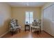 Cozy bedroom with floral armchairs, hardwood floors, and a window with blinds, creating a warm and inviting atmosphere at 17490 Se 110Th Ter, Summerfield, FL 34491