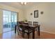 Dining area with a wooden table, six chairs, hardwood floors, and sliding glass doors leading to the lanai at 17490 Se 110Th Ter, Summerfield, FL 34491